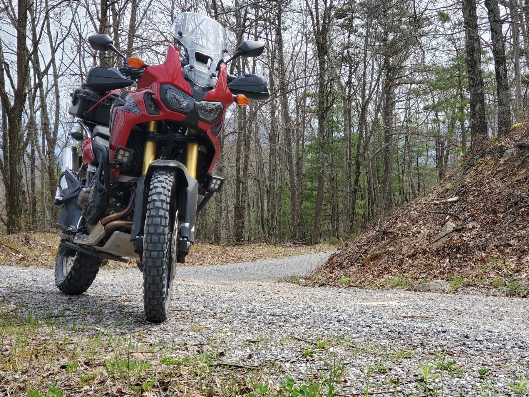 Red adventure motorcycle with gear at a scenic overlook