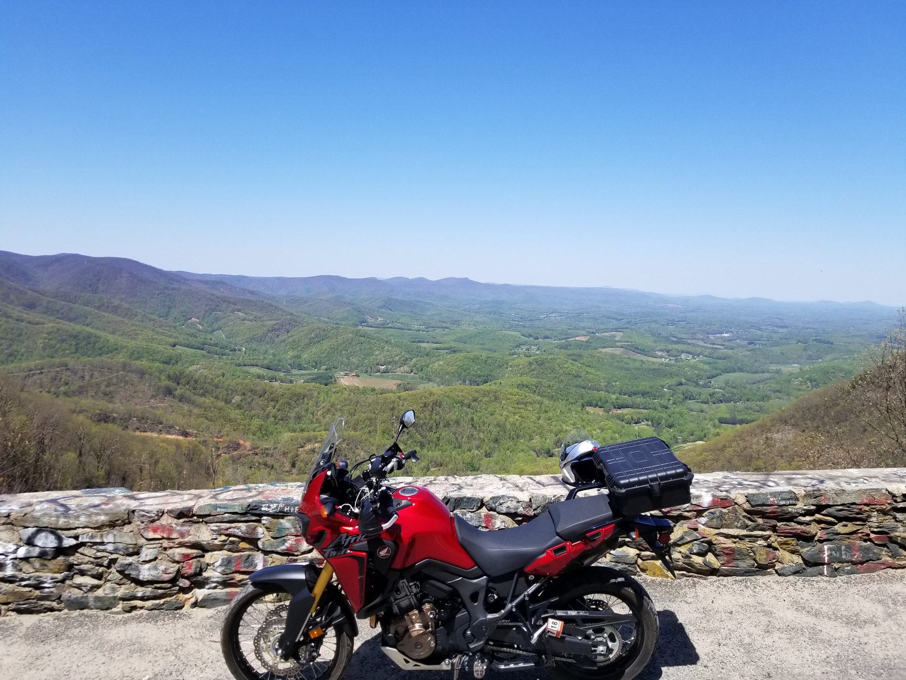 Red adventure motorcycle on a gravel forest path